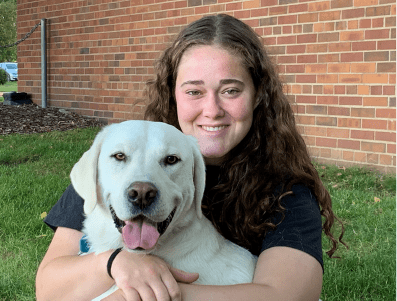 woman hugging her white dog